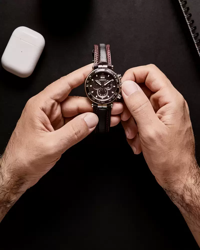 Manos girando la corona del reloj para darle cuerda manual - técnica correcta de energización