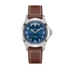 Hamilton Khaki Field King Day-Date H64475540 visto en la muñeca, con caja de acero de 40 mm, esfera azul, indicador de día y fecha y correa de cuero marrón.