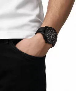 Tissot Chrono XL Vintage negro en la muñeca, combinado con camisa blanca y pantalón oscuro.