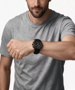 Hombre con remera gris usando el Tissot Chrono XL Vintage de 45 mm con correa de cuero negra.