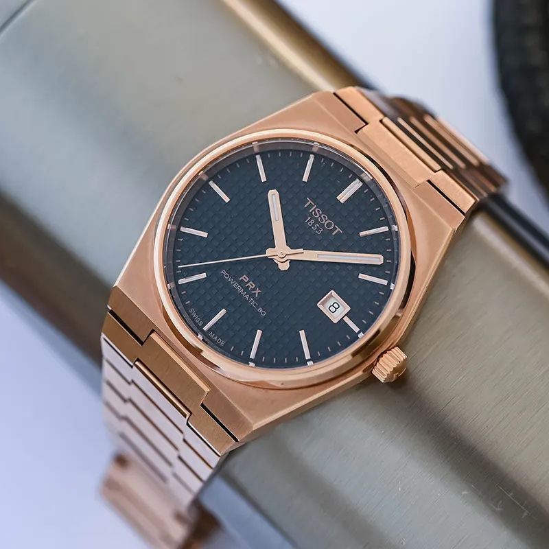 Primer plano del Tissot PRX T137.407.33.041.00 con esfera azul cuadriculada y caja color oro rosa